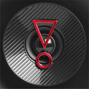 Close-up of black circular surface with red triangle and circle design elements creating an abstract geometric pattern on textured background.
