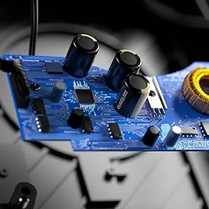 Close-up of a blue circuit board with black capacitors and electronic components against a dark background with selective focus.