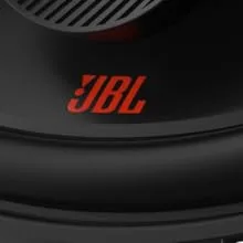 De tekst luidt 'JBL' in rode letters op een zwart oppervlak, het lijkt een merkdetail van de luidspreker of audioapparatuur te zijn.