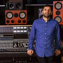 Serie beelden van iemand in een blauw shirt in wat lijkt op een opnamestudio of omgeving met audioapparatuur.