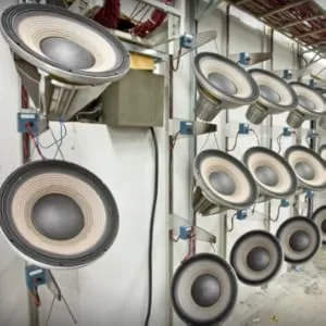 Interieur van de industriële wasruimte met meerdere grote commerciële wasmachines die aan de muur zijn gemonteerd, met ronde glazen deuren zichtbaar.