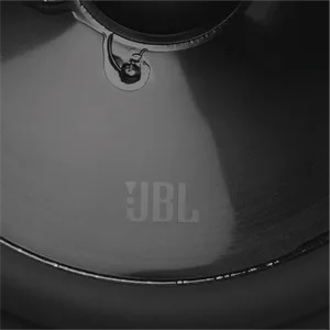 De tekst luidt 'JBL'. Detailopnamen van dichtbij van een zwart luidsprekeroppervlak waarop verschillende hoeken van het gebogen ontwerp en het merklogo te zien zijn.