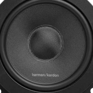 De tekst luidt 'harman/kardon'. Zwarte ronde autospeaker of audiodriver met getextureerde conus en bevestigingspunten.